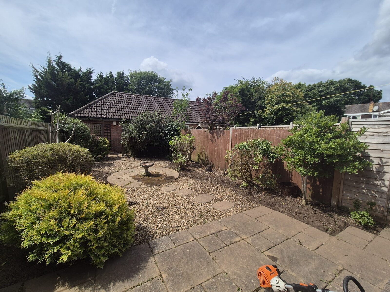 Gravel garden with stepping stones and a stone bird bath