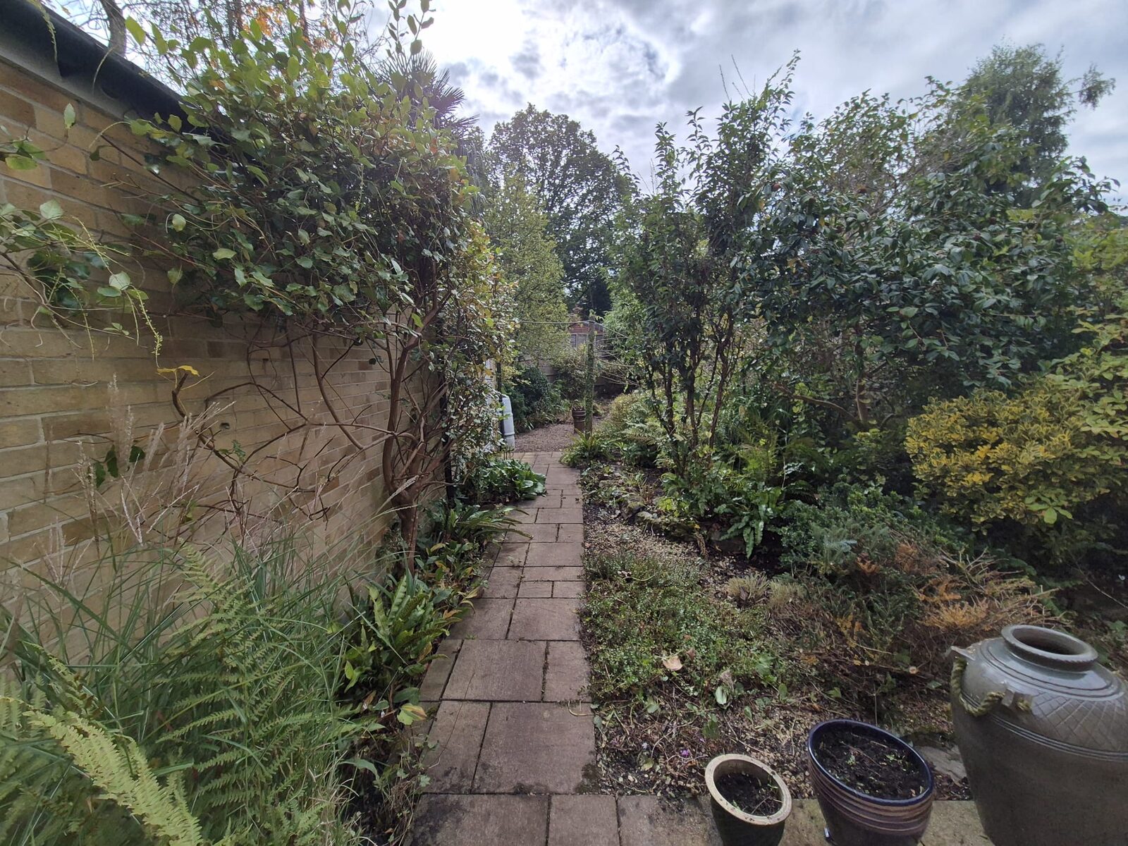 Stone path through a shaded, planted garden corner