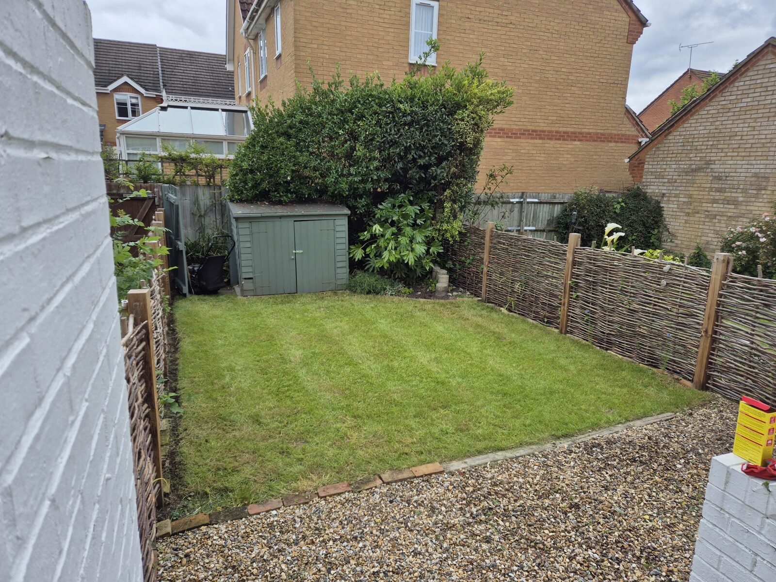 Tidy lawn with hedge and garden shed